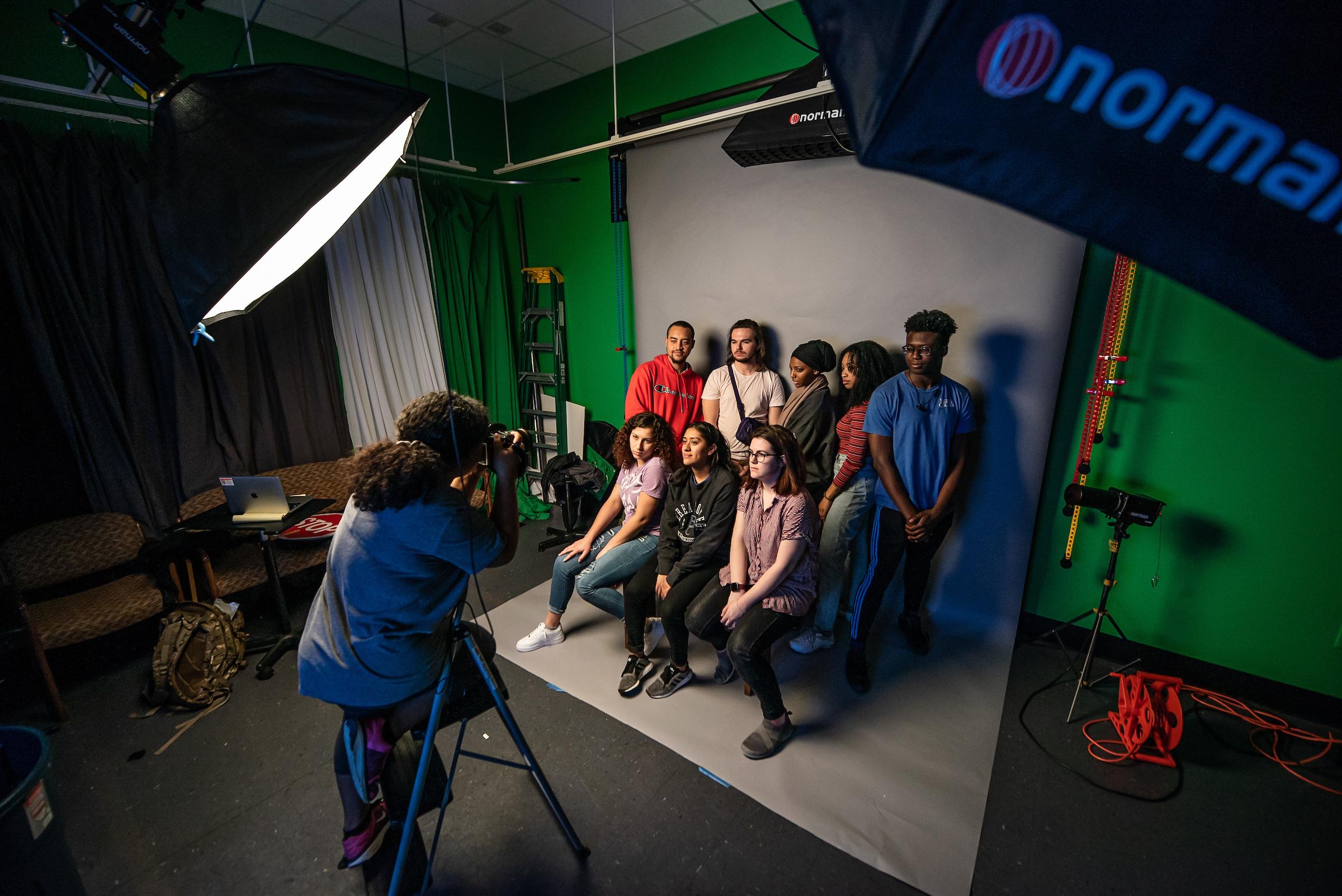 Student photographer taking pictures of a group in the studio