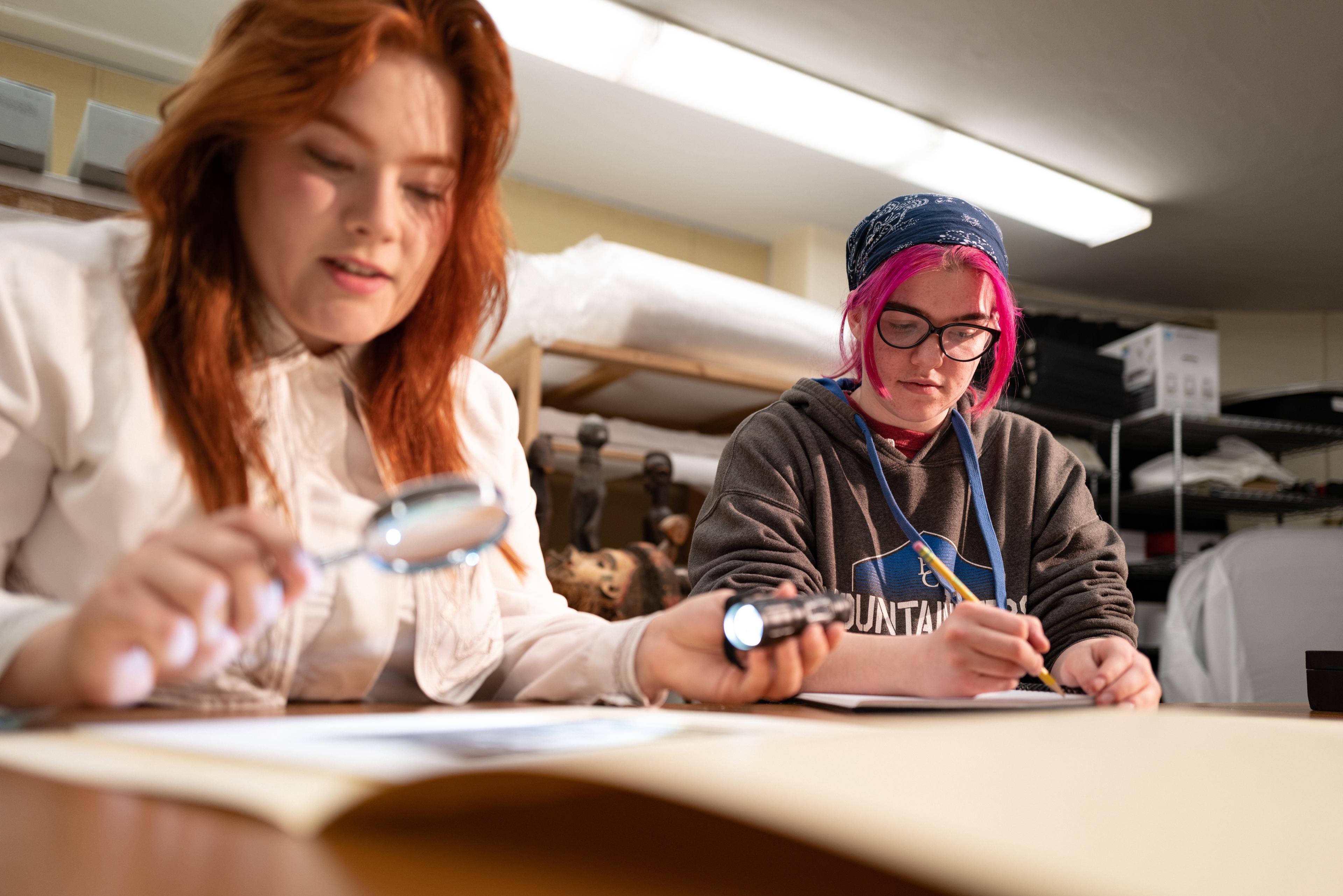 Student workers inspecting art in the Doris Ulmann Galleries